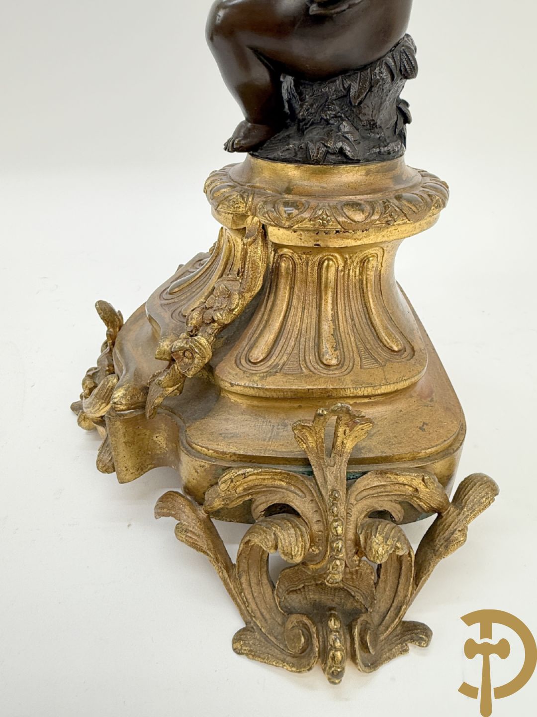 Driedelige bronzen garnituur bestaande uit middenstuk met bronzen vuurvergulde klok, Daubrée gemerkt à Nancy, bovenaan bekroond met Cleopatra met drinkbeker - getekend van Cumberworth sculpteur - geflankeerd door paar cupido