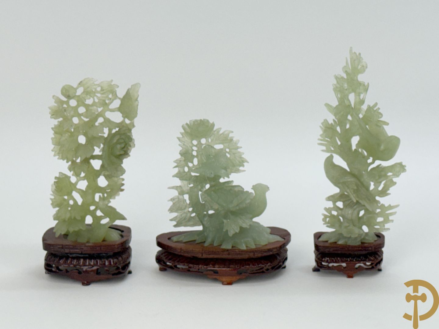 Drie jade sculpturen van vogels met bloemen op sokkel