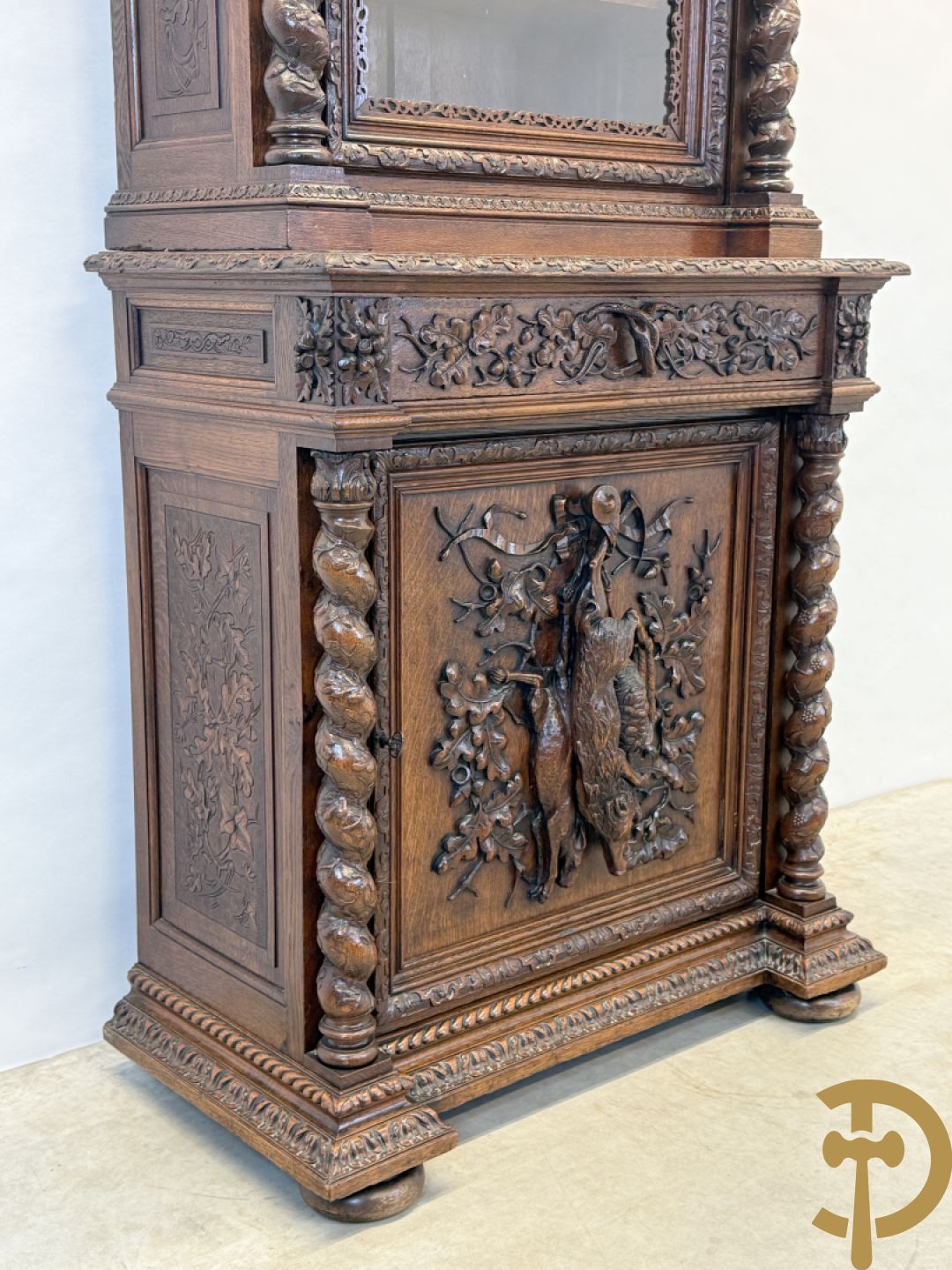 Massief eiken jacht deux-corps, bovenaan met vitrine, zijdelings met getorste zuilen, onderaan met sculptuur van everzwijn en eikebladranken