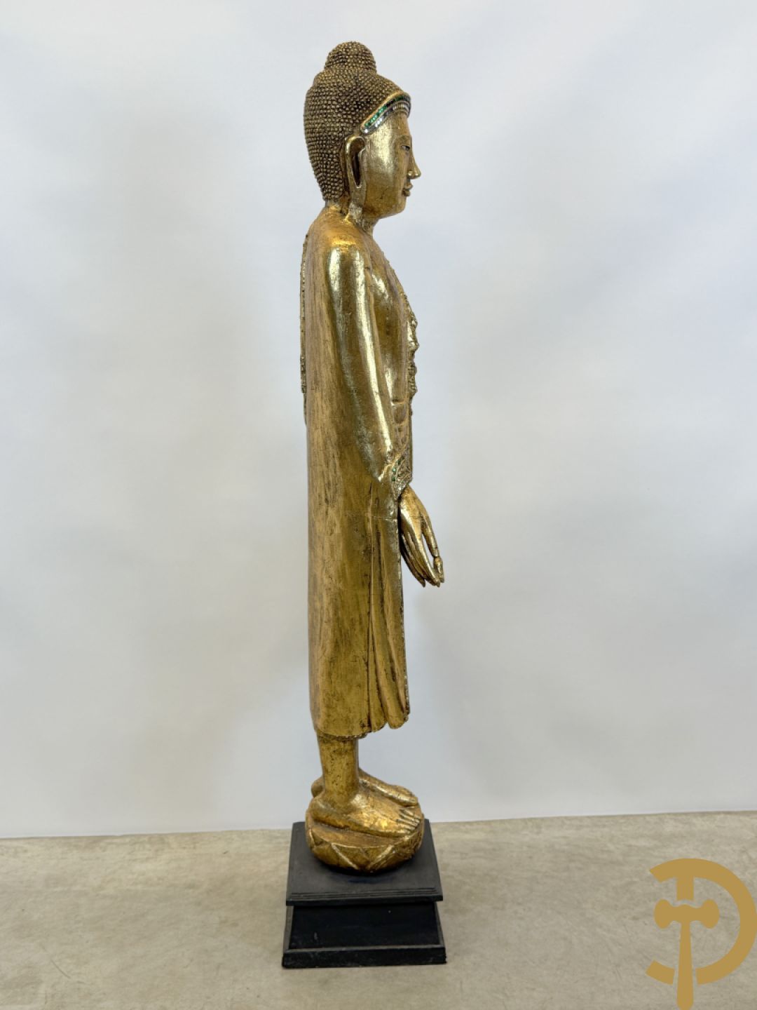 Vergulde houtgesculpteerde staande boedha bezet met spiegeltjes, op sokkel