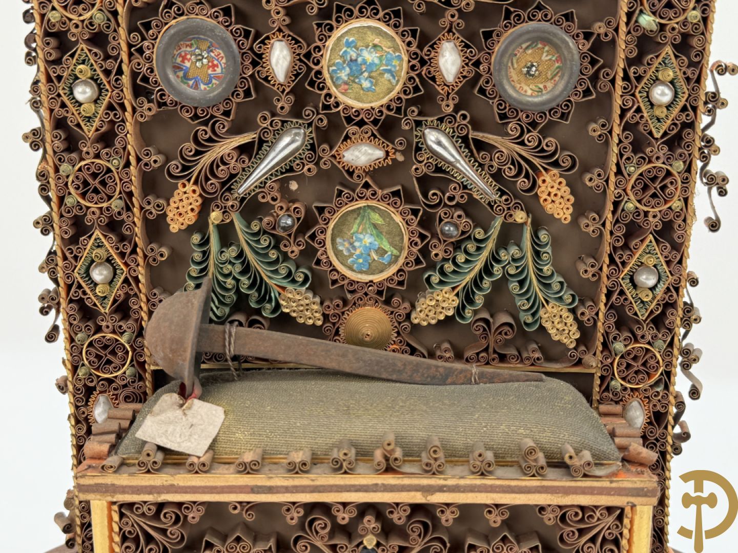 Relikwiehouder in de vorm van een altaar met Christusnagel en omgeven door papperollen - onder stolp