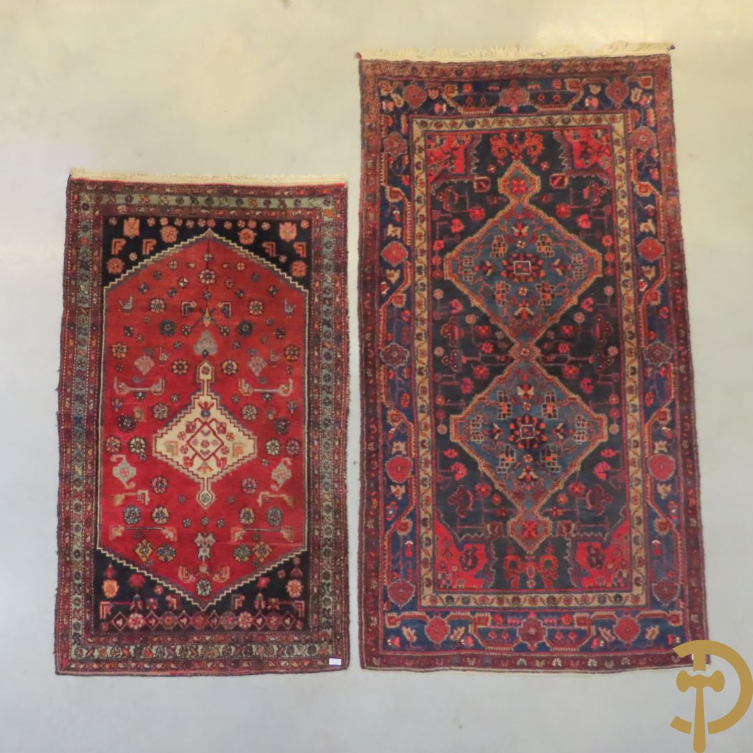 Oosterse handgeknoopt tapijt met geometrische motieven op blauwe fond Malayer + Oosters handgeknoopt tapijt met bloemenpatronen rode fond Kashkay