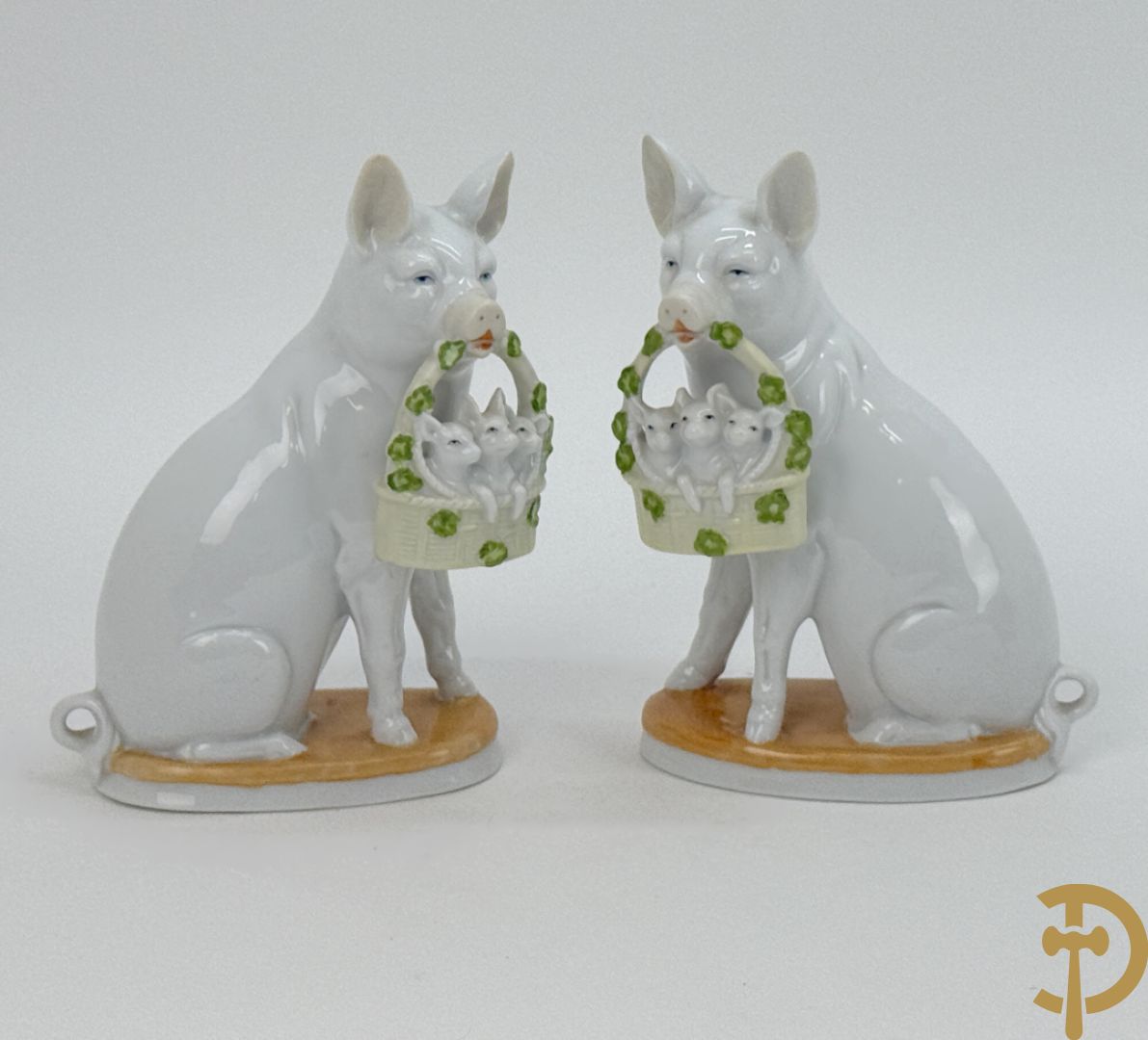 Koppel porseleinen beeldjes met varkens houdende een mandje met biggetjes