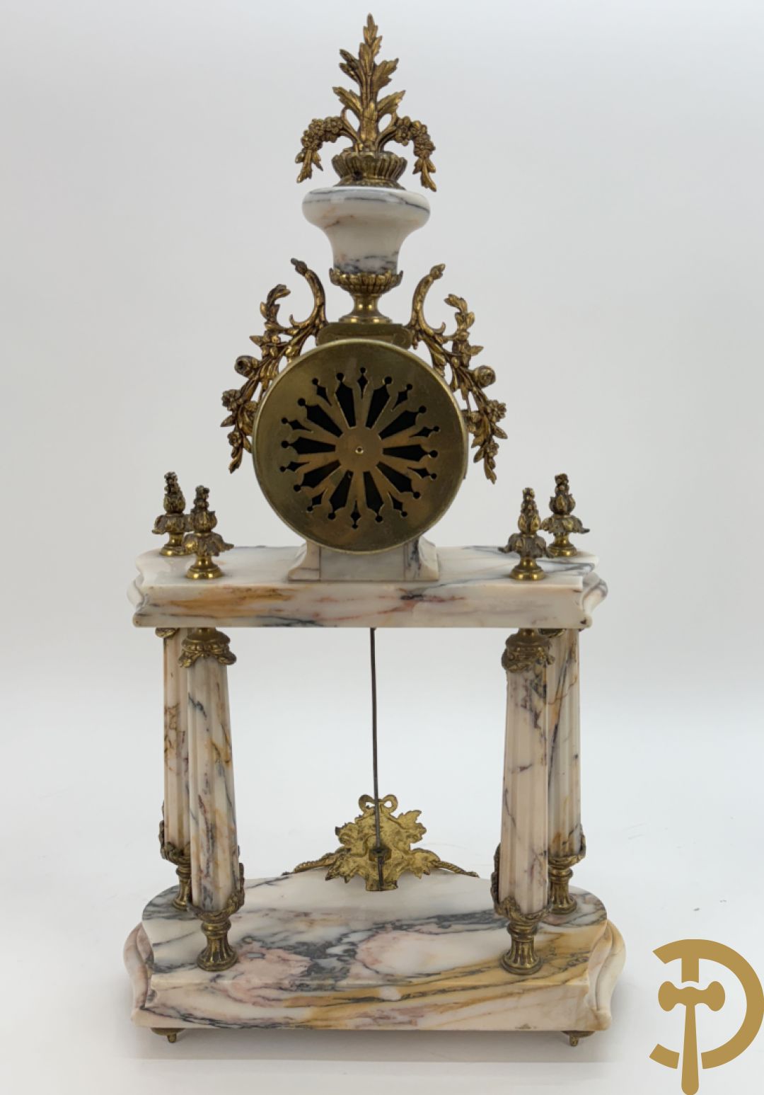 Driedelige wit marmeren garnituur bestaande uit vierzuilenpendule met bloemen en troffee geflankeerd door paar cassolettes met ramskoppen bezet