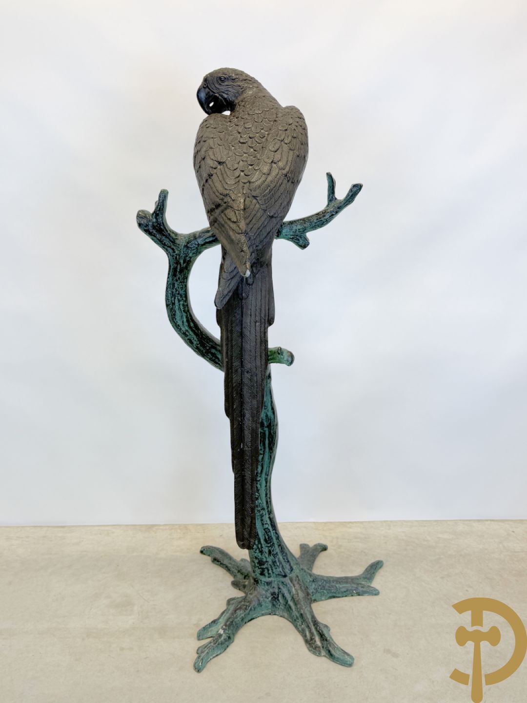 Metalen gepatineerde papegaai op boomstronk