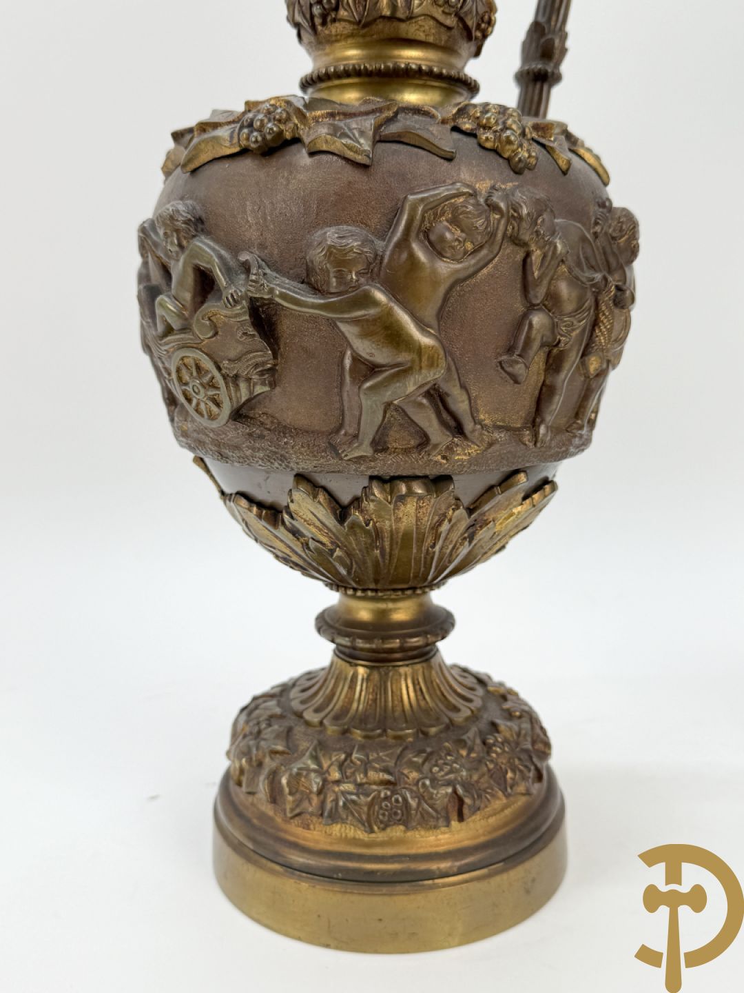 Paar bronzen schenkkannen met basrelief van putti en accanthusranken