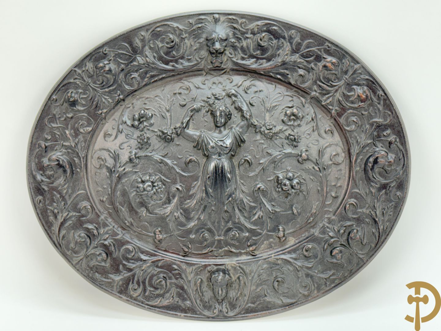 Metalen ovale schotel met dame omgeven door bloemen en accanthusranken, achteraan getekend American Radiator Cie