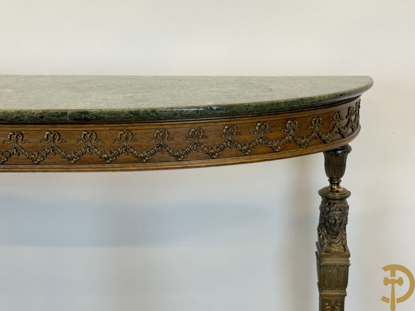 Console op bronzen poten met dameshoofden bezet, bovenaan met groen marmeren blad