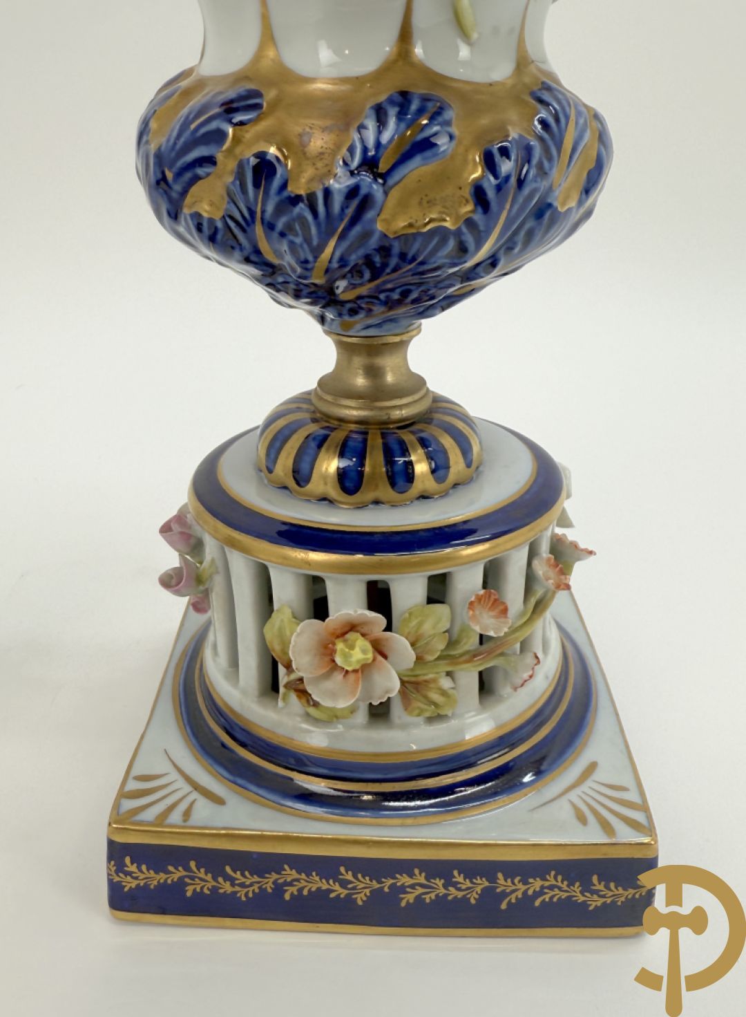 Porseleinen siervaas met handbeschilderd geanimeerd decor bezet met basrelief van bloemen en bovenaan bekroond met deksel met vogel