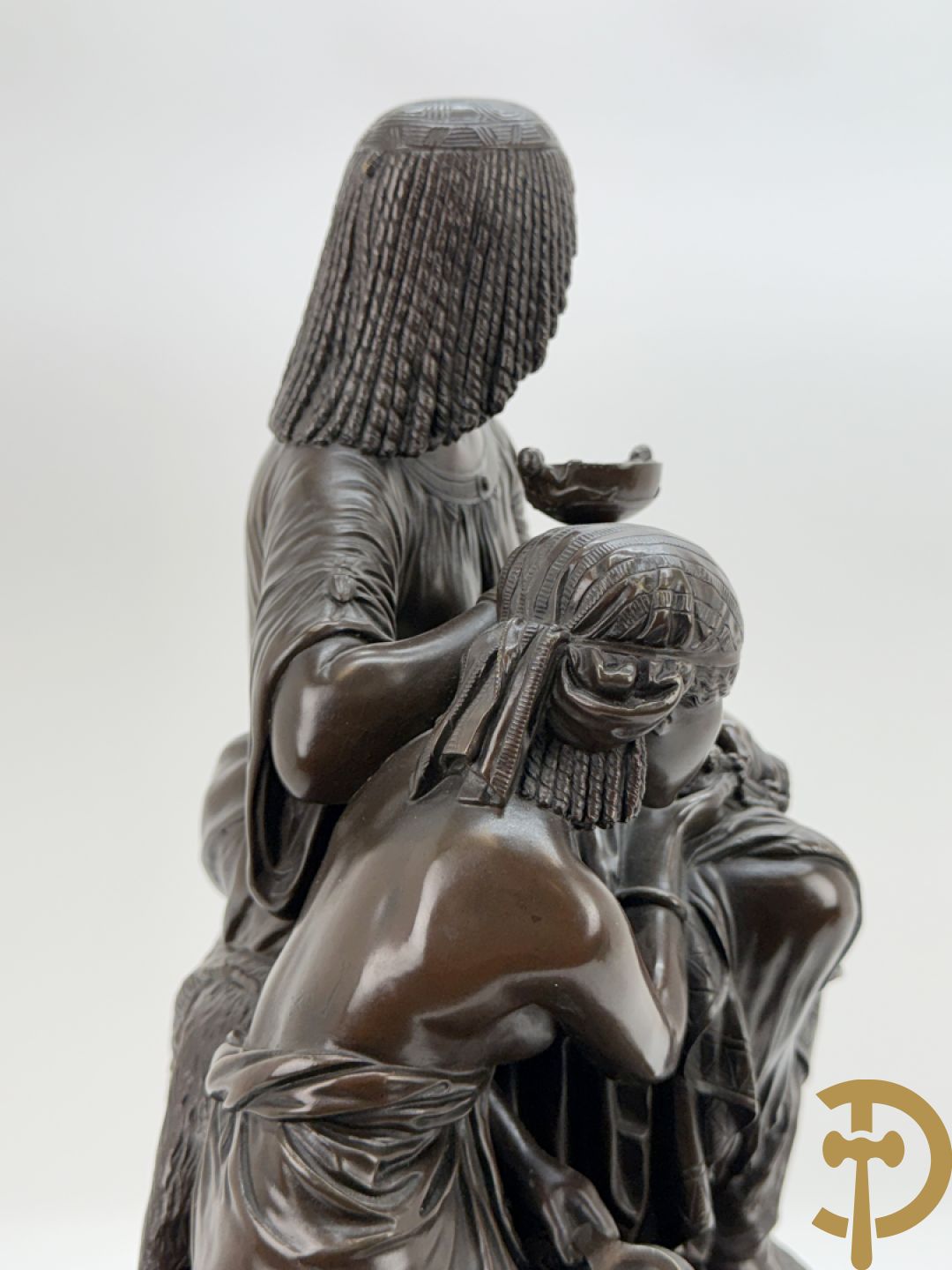 Driedelige bronzen garnituur bestaande uit middenstuk met bronzen vuurvergulde klok, Daubrée gemerkt à Nancy, bovenaan bekroond met Cleopatra met drinkbeker - getekend van Cumberworth sculpteur - geflankeerd door paar cupido