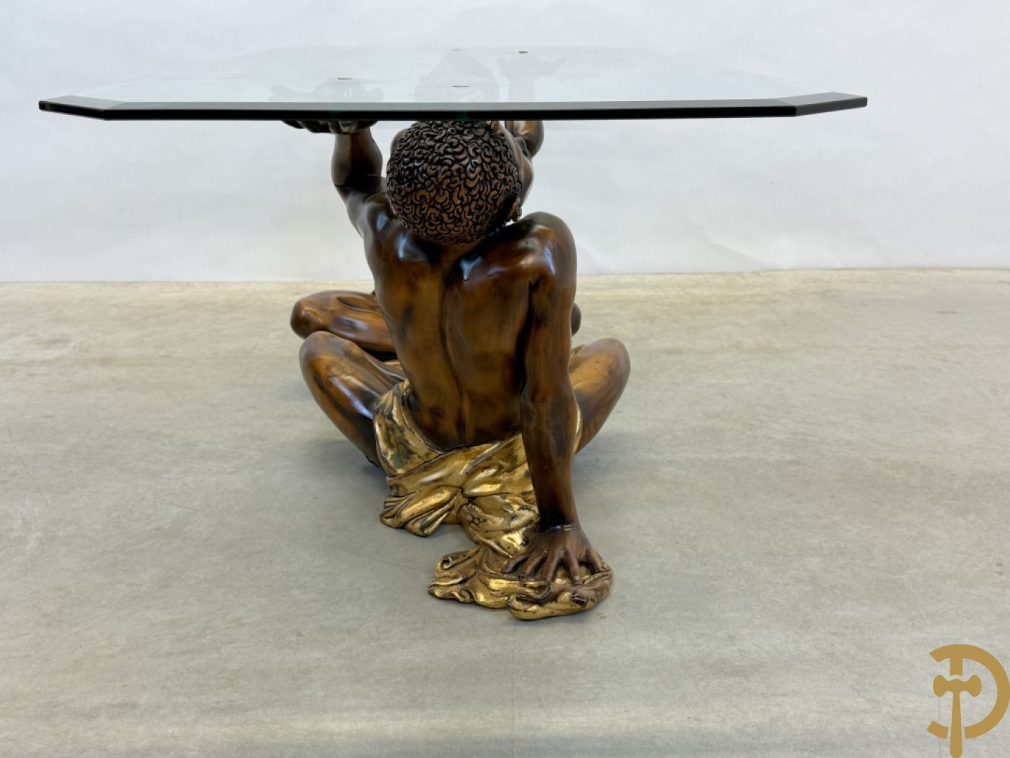 Salontafel met een paar moren met vergulde lendendoek dragende een achthoekig geslepen glazen blad