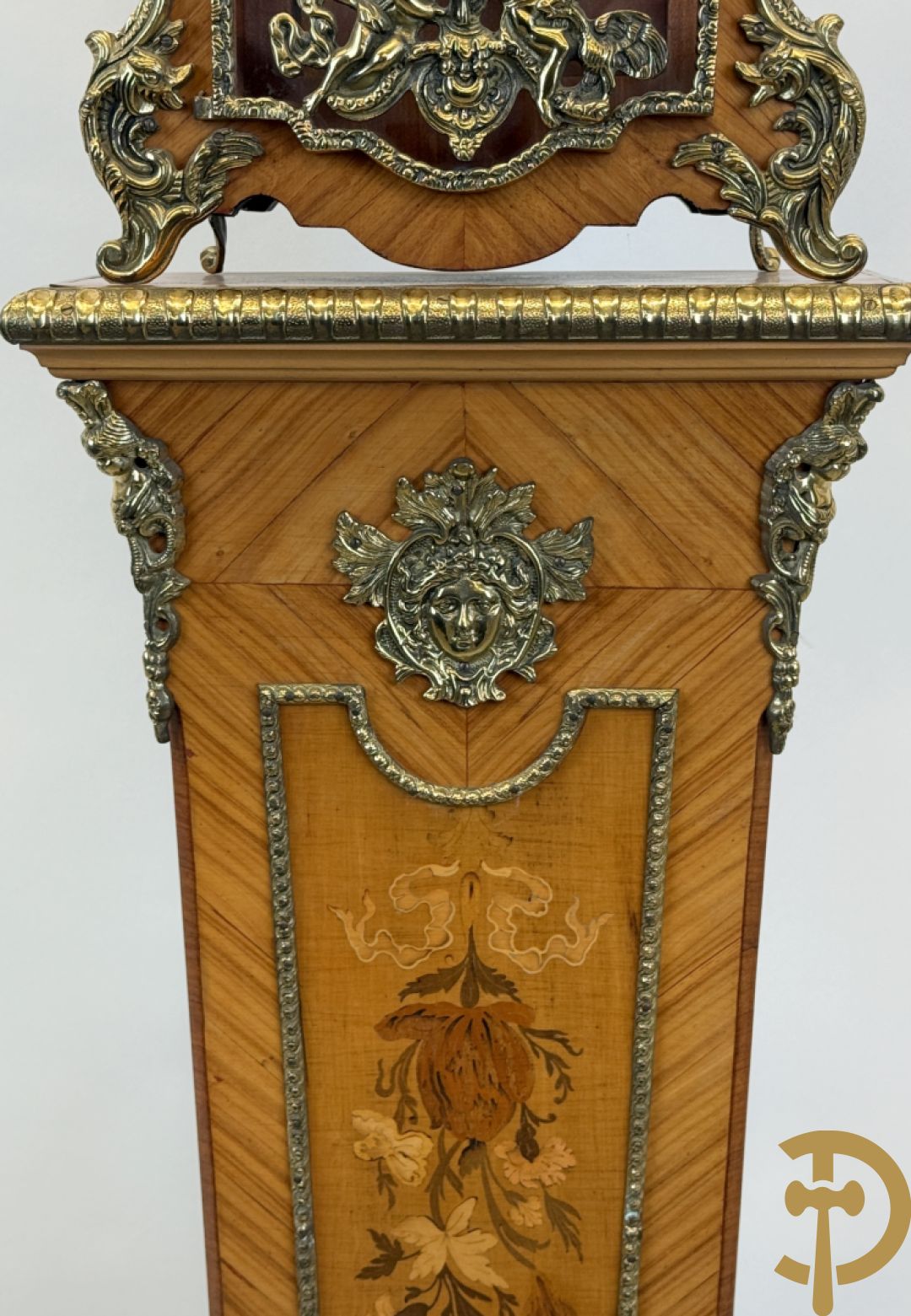 Notelaren pendule met bloemenmarquetterie en bronsbeslag, bovenaan bekroond met bronzen figuur - met bijhorende sokkel in notelaar met bronsbeslag