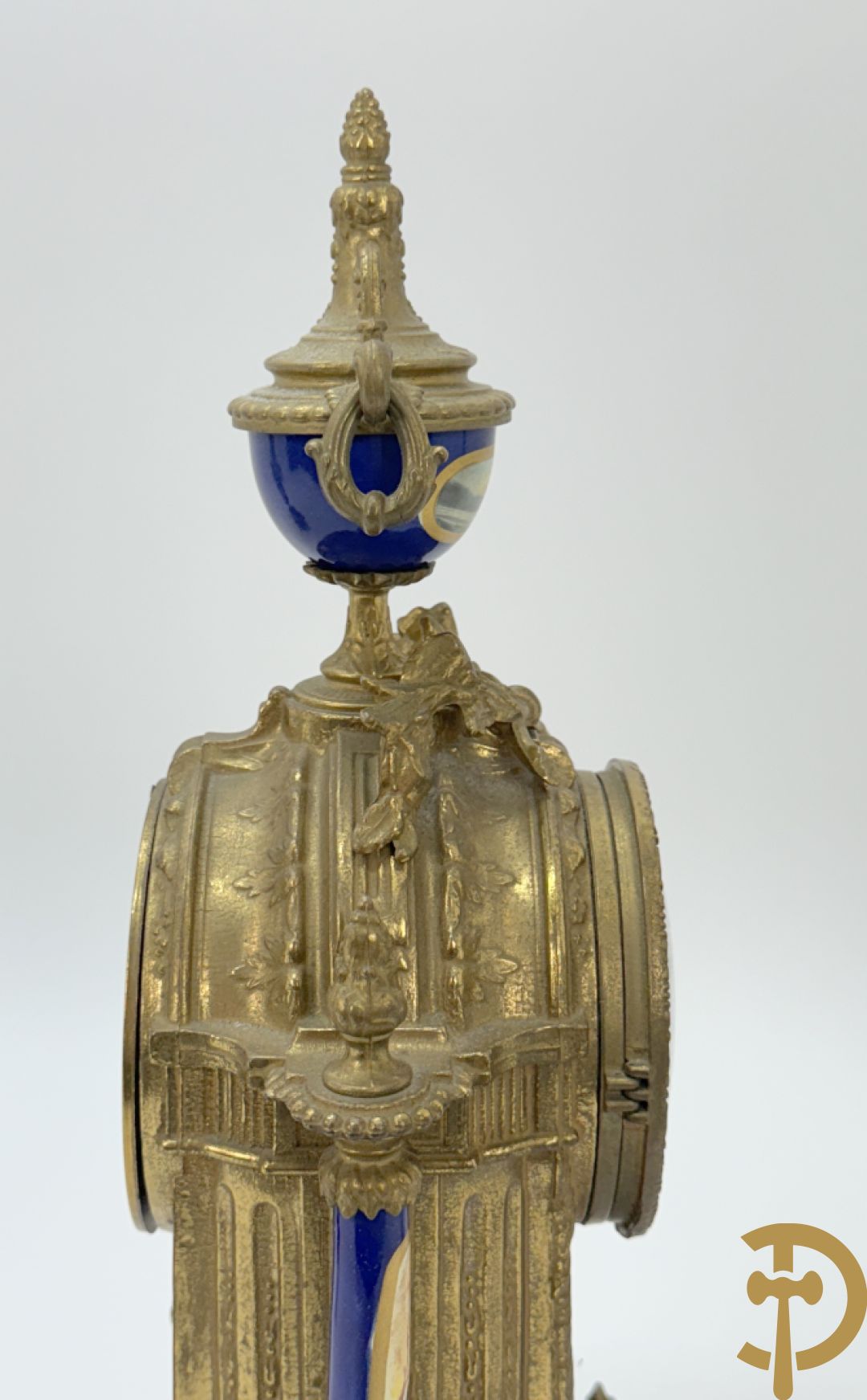 Driedelige koperen garnituur bestaande uit pendule met beschilderd romantisch tafereel en amfoor, zijdelings bezet met paar cassolettes met geanimeerde scènes, onleesbaar getekend rechts onder klok