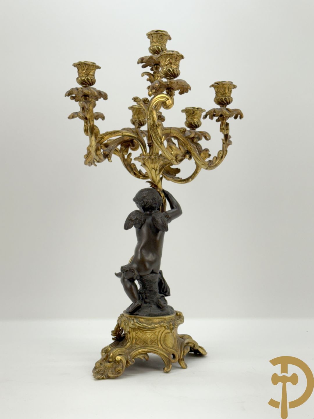 Bronzen cupido dragende een zevenarmige kandelaar