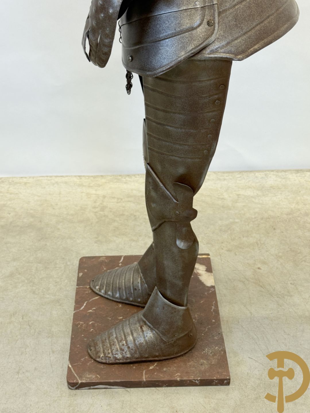 Decoratief plaatstalen ridderharnas met zwaard op marmeren voet