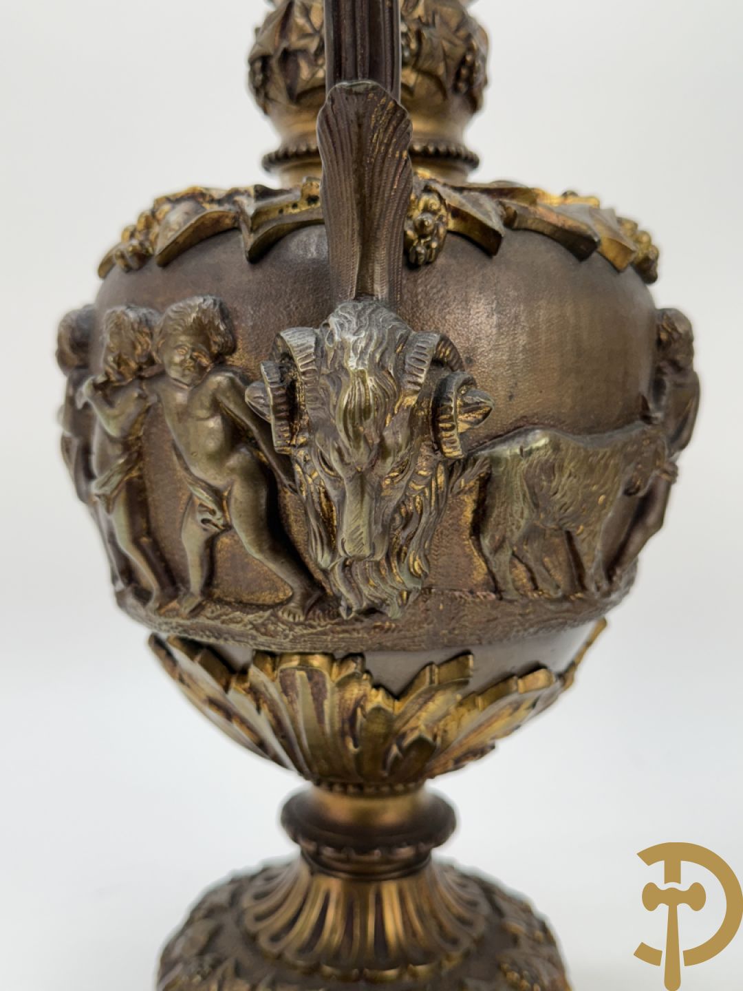 Paar bronzen schenkkannen met basrelief van putti en accanthusranken