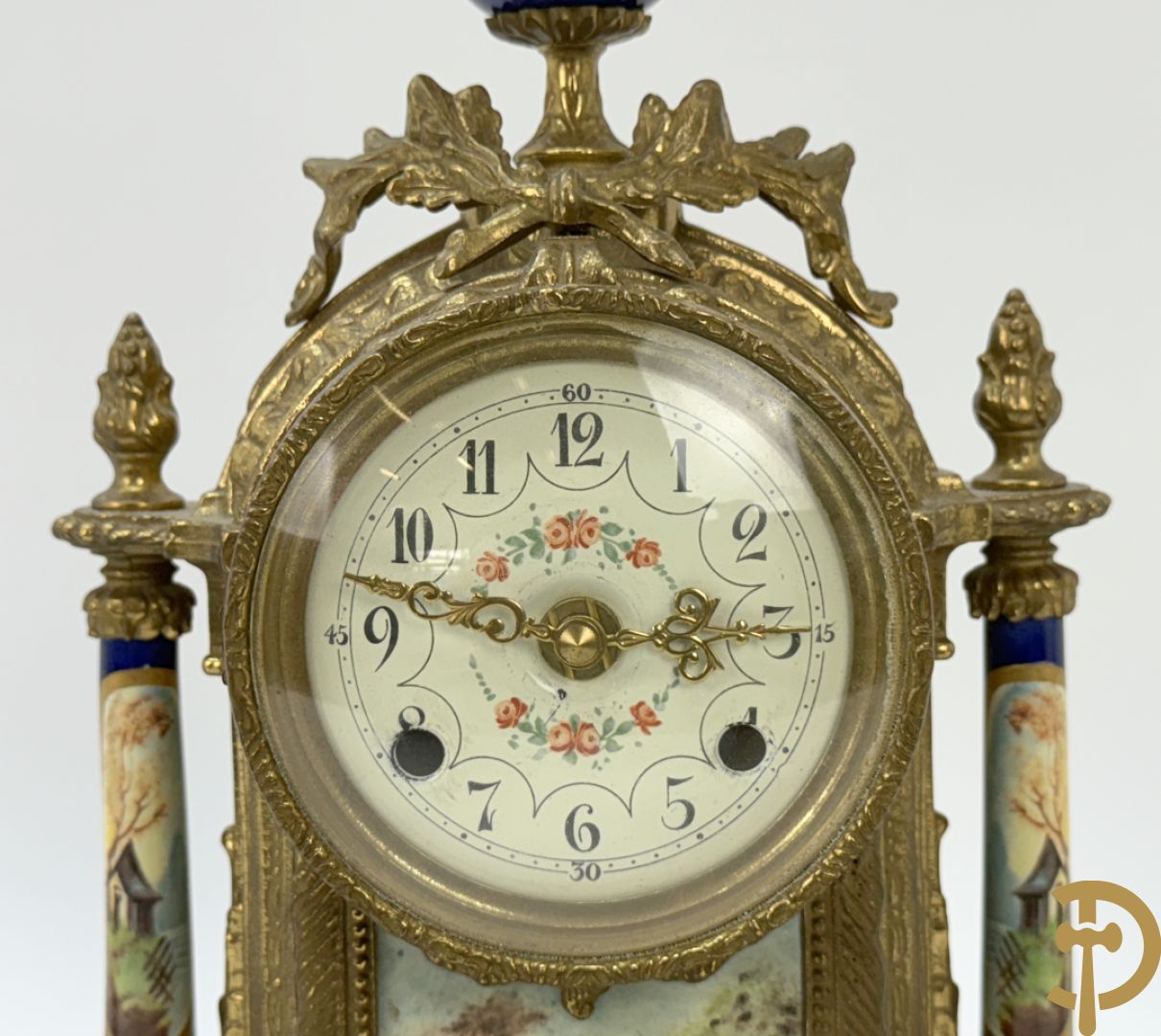 Driedelige koperen garnituur bestaande uit pendule met beschilderd romantisch tafereel en amfoor, zijdelings bezet met paar cassolettes met geanimeerde scènes, onleesbaar getekend rechts onder klok