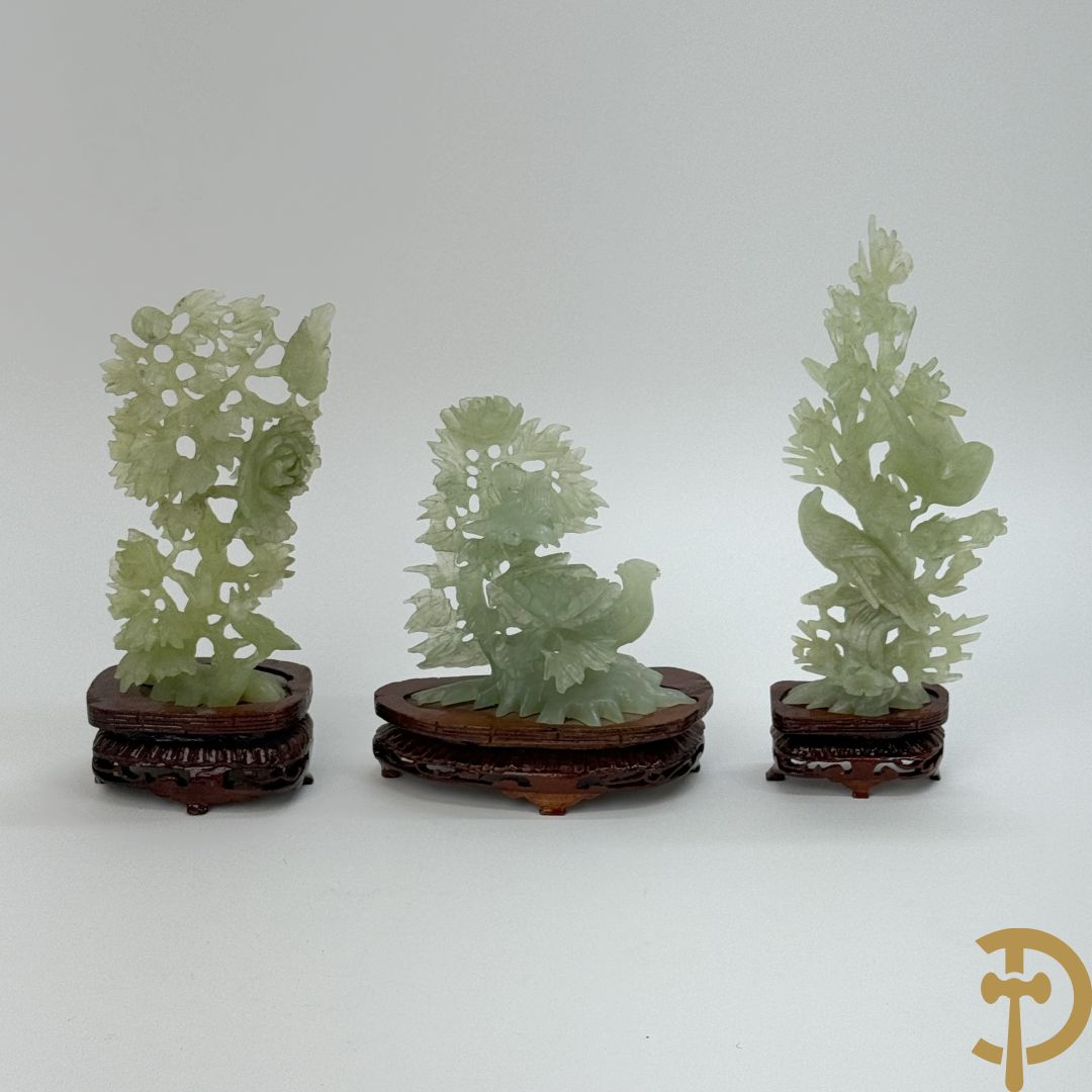 Drie jade sculpturen van vogels met bloemen op sokkel