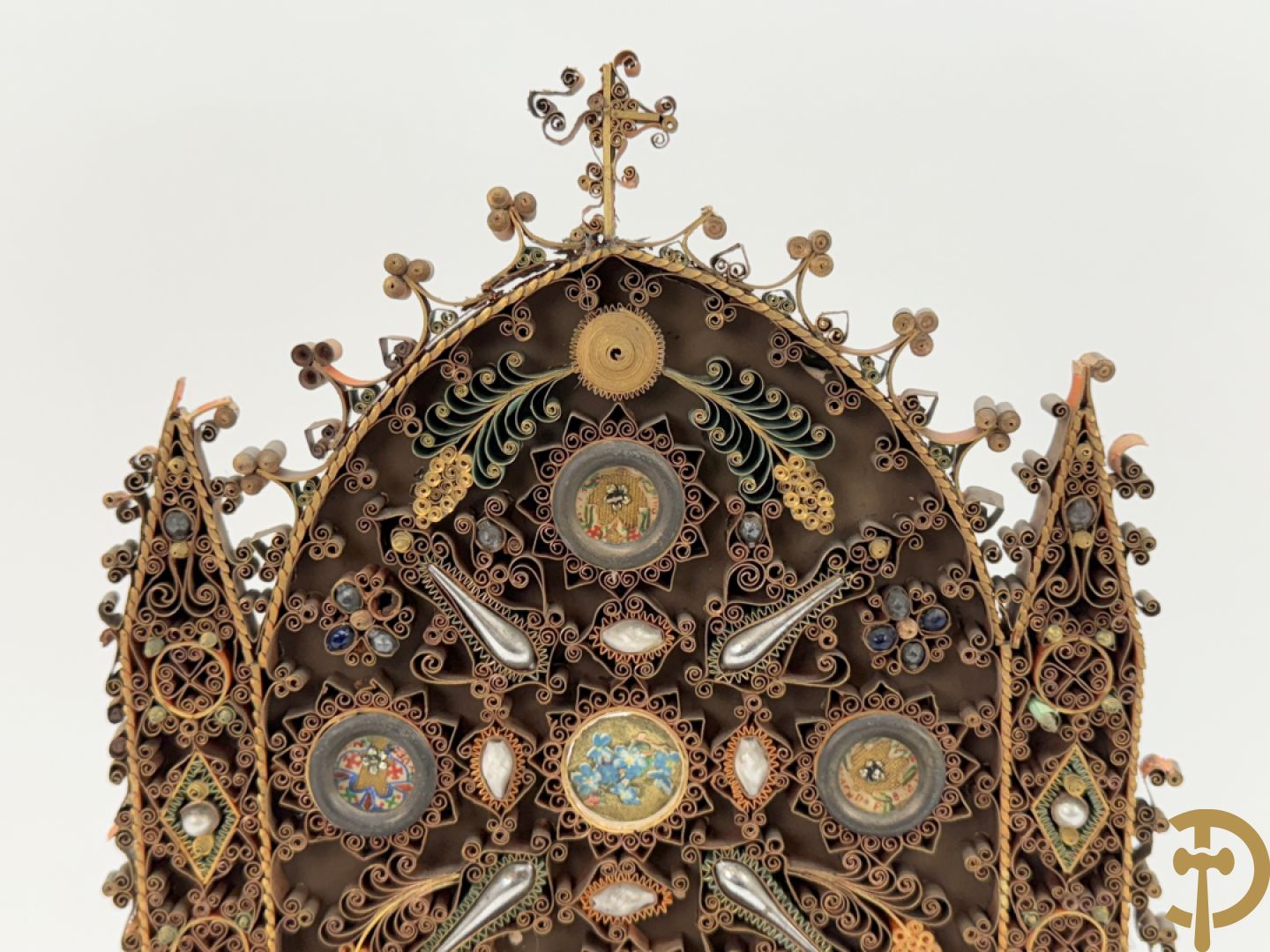 Relikwiehouder in de vorm van een altaar met Christusnagel en omgeven door papperollen - onder stolp