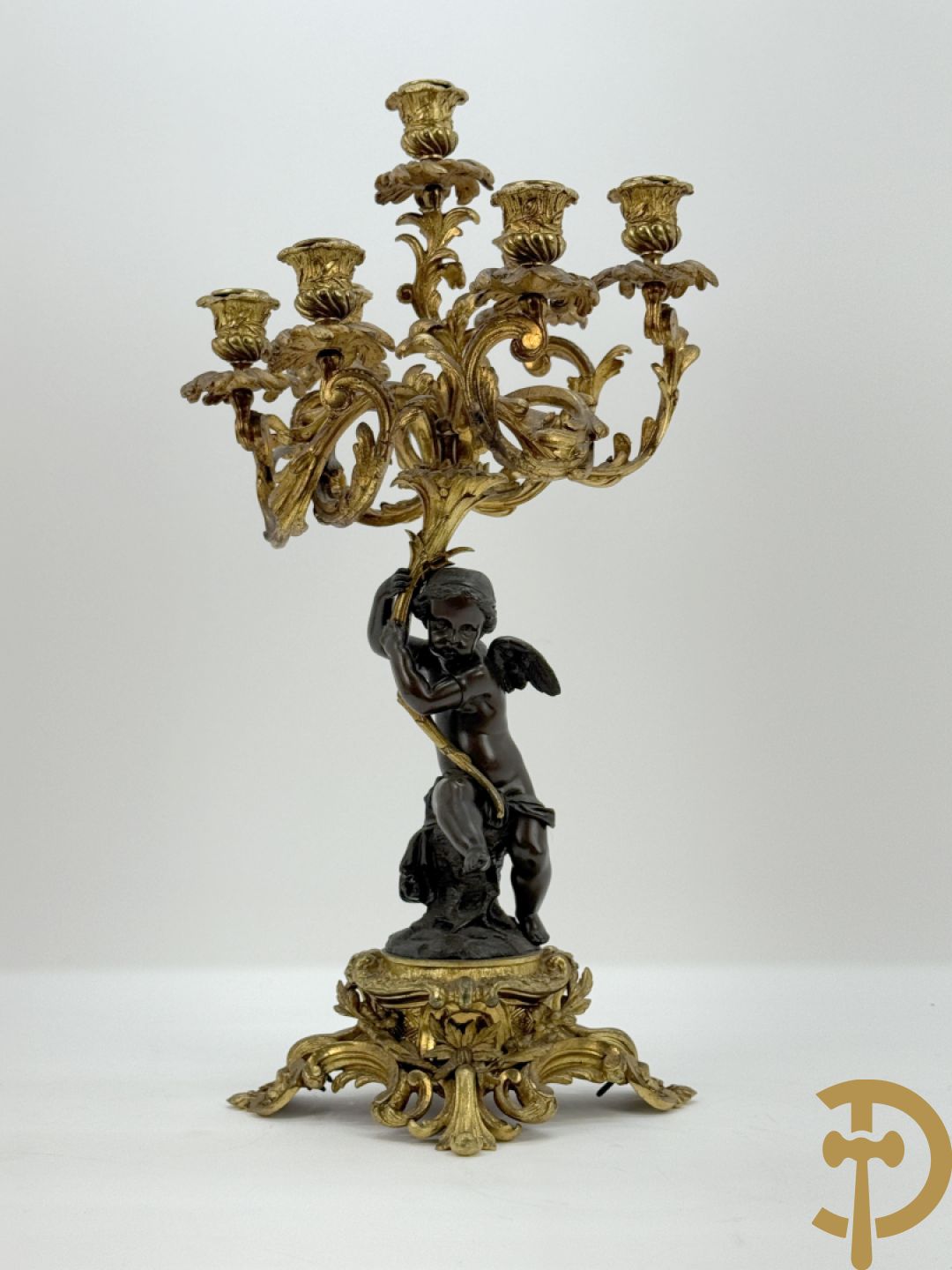 Bronzen cupido dragende een zevenarmige kandelaar