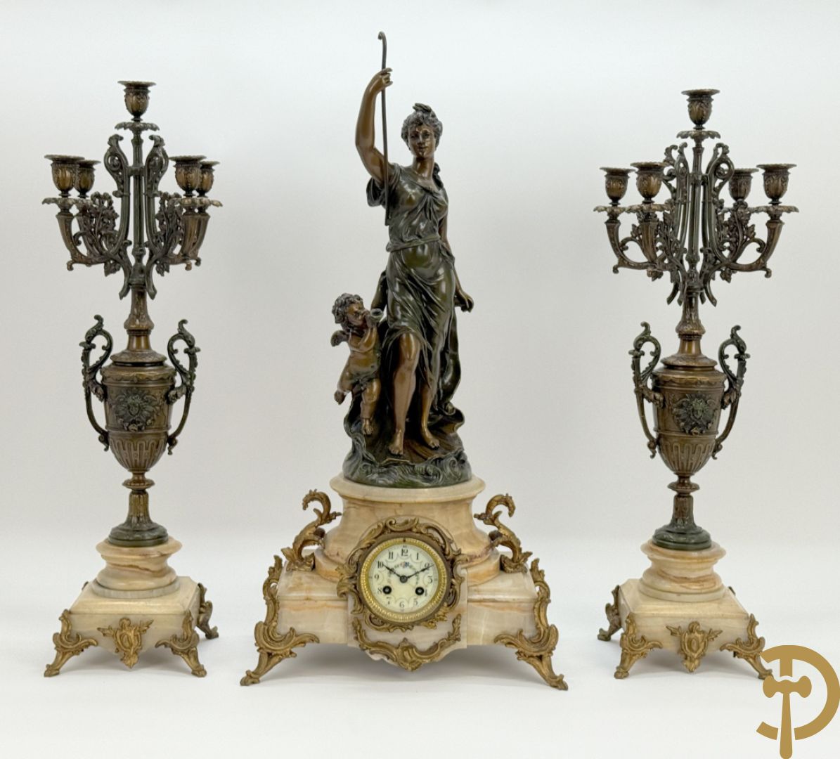 Driedelige zamak garnituur bestaande uit pendule met cupido en dame geflankeerd door paar vijfarmige kandelaars, Bruchon getekend