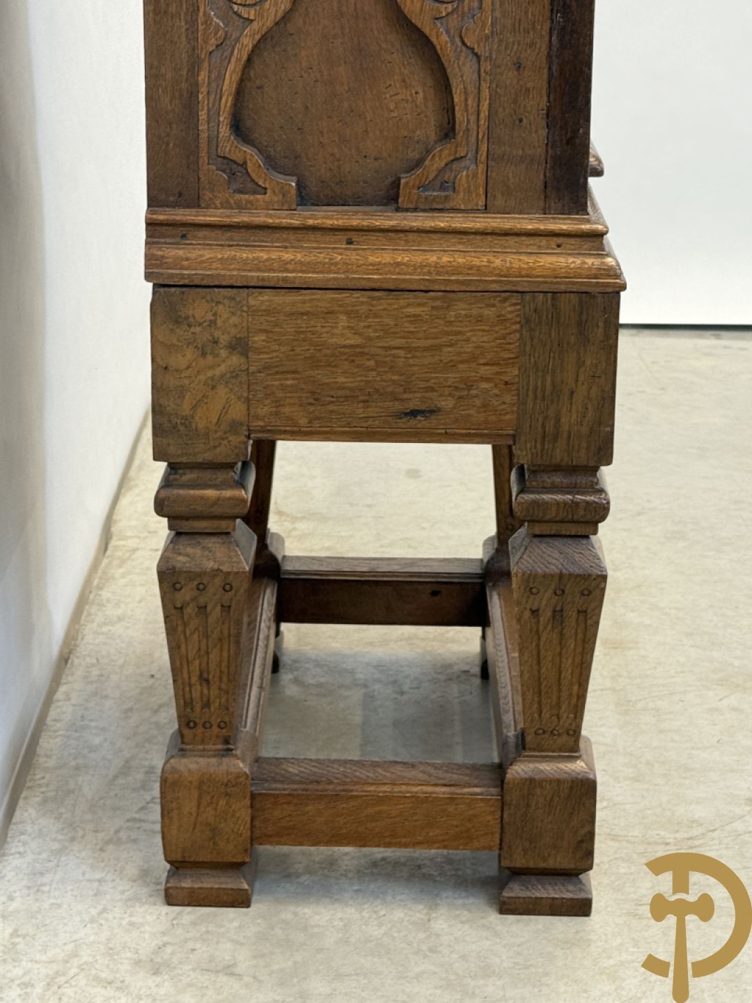 Massief eiken ééndeurskast op onderstel met lade bovenaan, lade onderaan, sculptuur in zijkant en deur