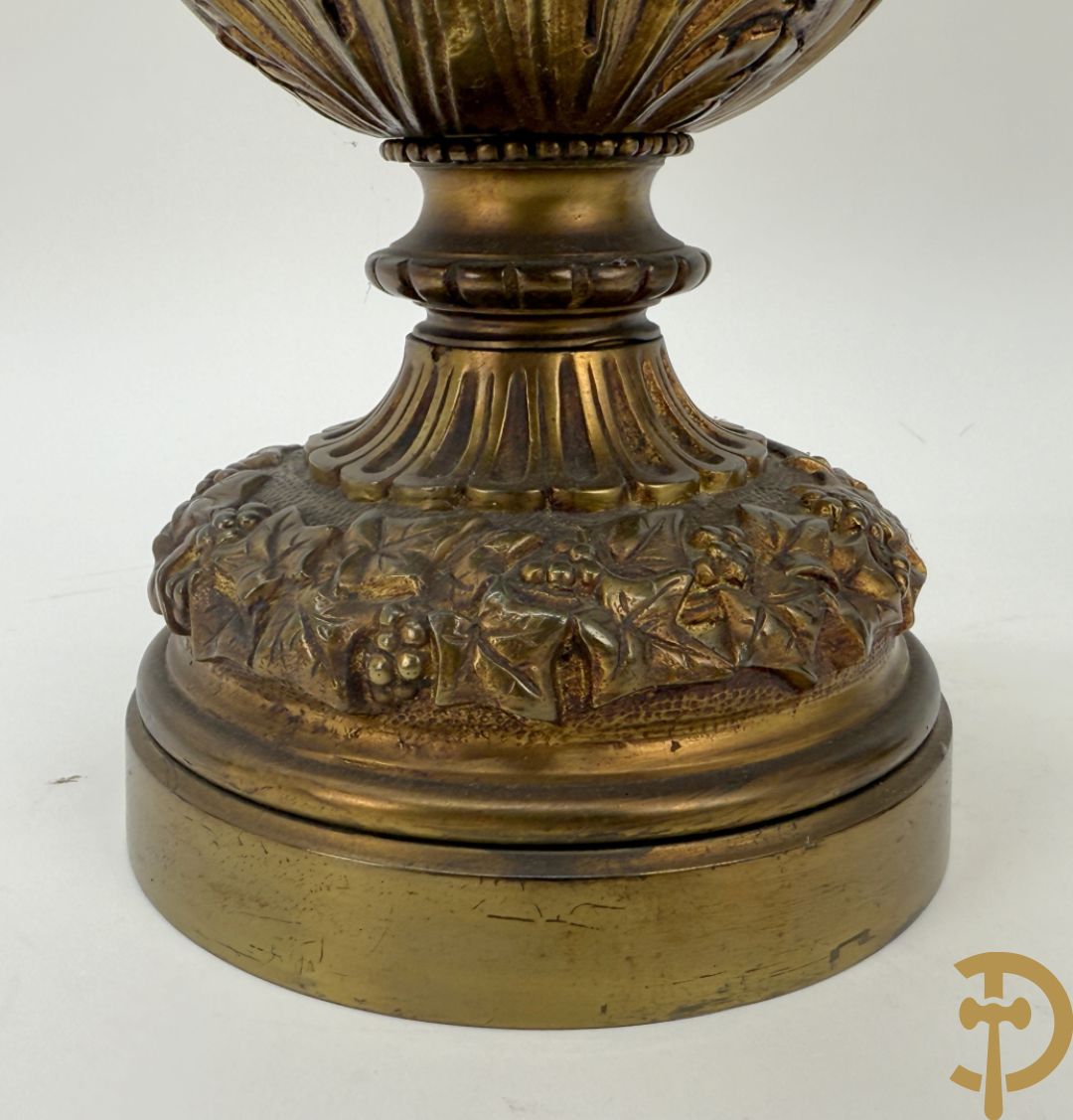 Paar bronzen schenkkannen met basrelief van putti en accanthusranken