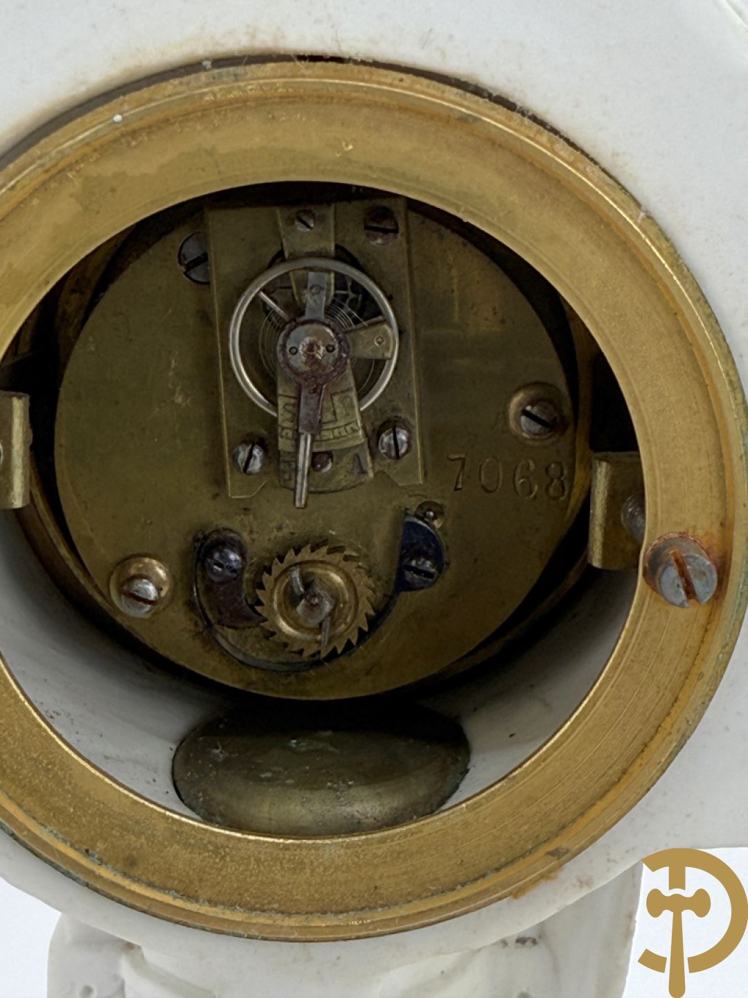 Driedelige porseleinen garnituur met bronsbeslag bestaande uit pendule met dame en amfoor geflankeerd door paar kandelaars bezet met personages