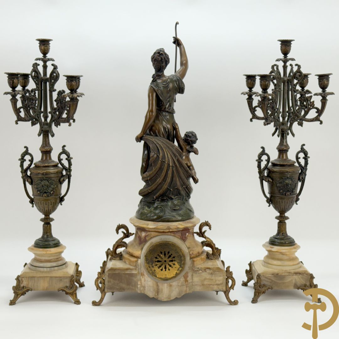 Driedelige zamak garnituur bestaande uit pendule met cupido en dame geflankeerd door paar vijfarmige kandelaars, Bruchon getekend