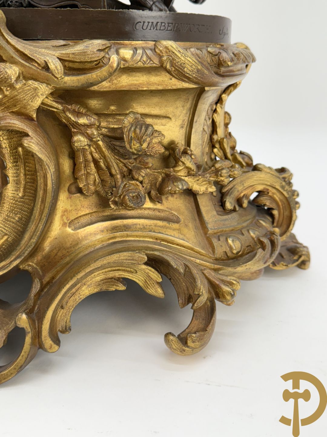 Driedelige bronzen garnituur bestaande uit middenstuk met bronzen vuurvergulde klok, Daubrée gemerkt à Nancy, bovenaan bekroond met Cleopatra met drinkbeker - getekend van Cumberworth sculpteur - geflankeerd door paar cupido