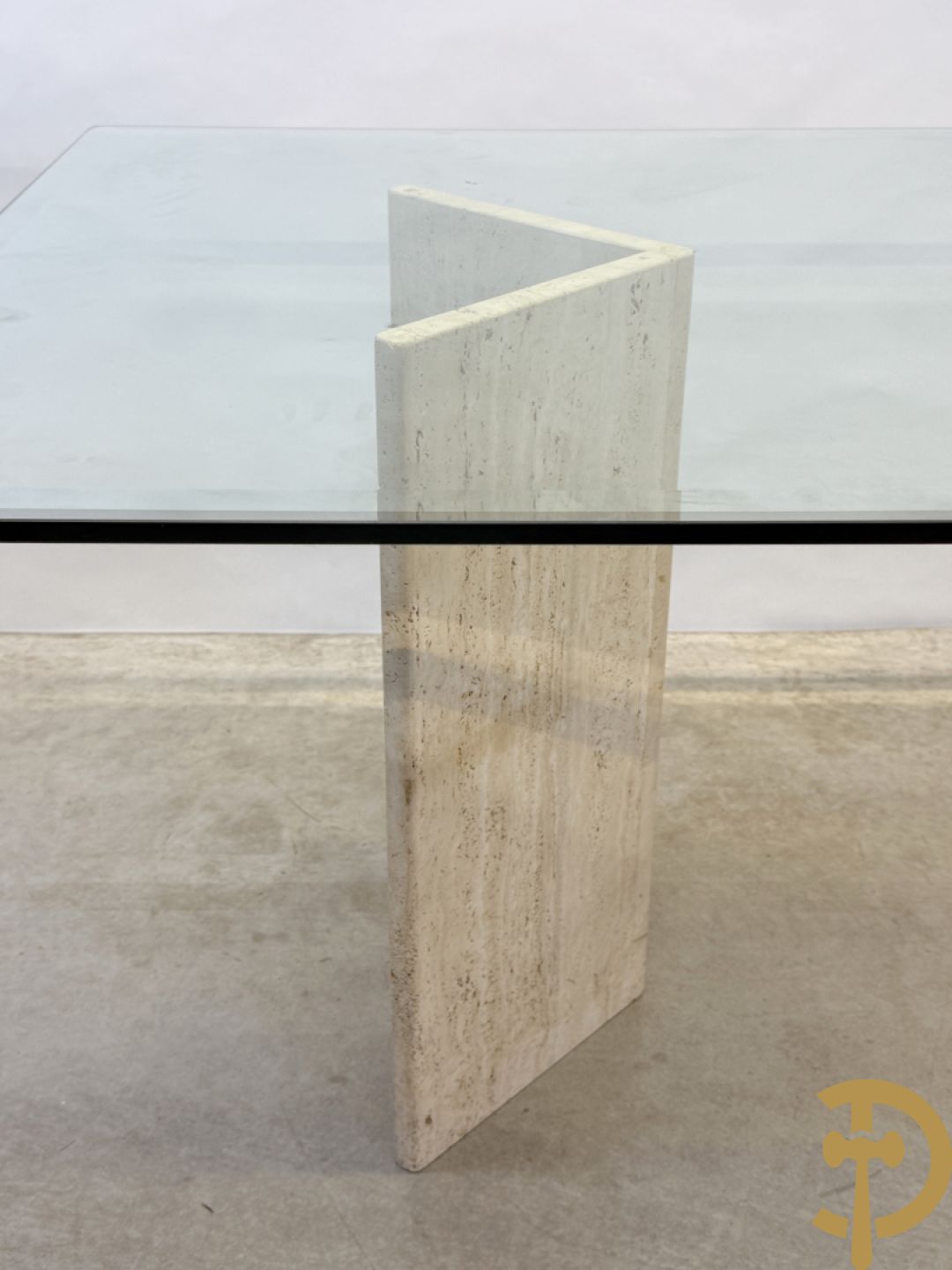 Moderne tafel met geslepen glazen blad op 2 travertin steunen