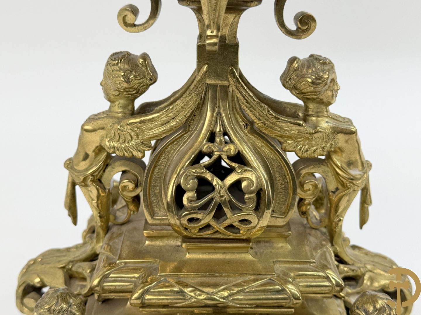 Driedelige bronzen vergulde garntiuur bestaande uit klok met medusahoofden en sfinxen, geflankeerd door paar zevenarmige kandelaars met accanthusranken en sfinxen