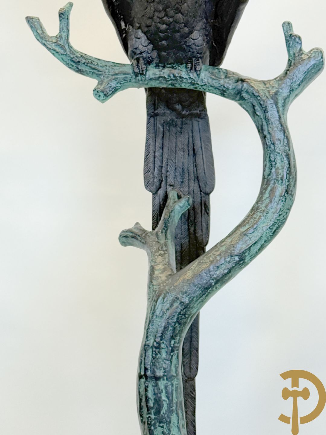 Metalen gepatineerde papegaai op boomstronk