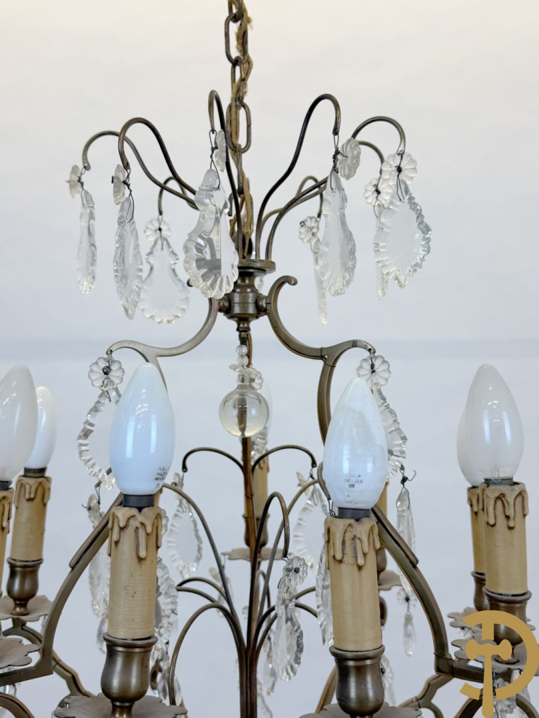 Franse koperen luchter met 8 lichtpunten en kristallen bellen op koperen chassis