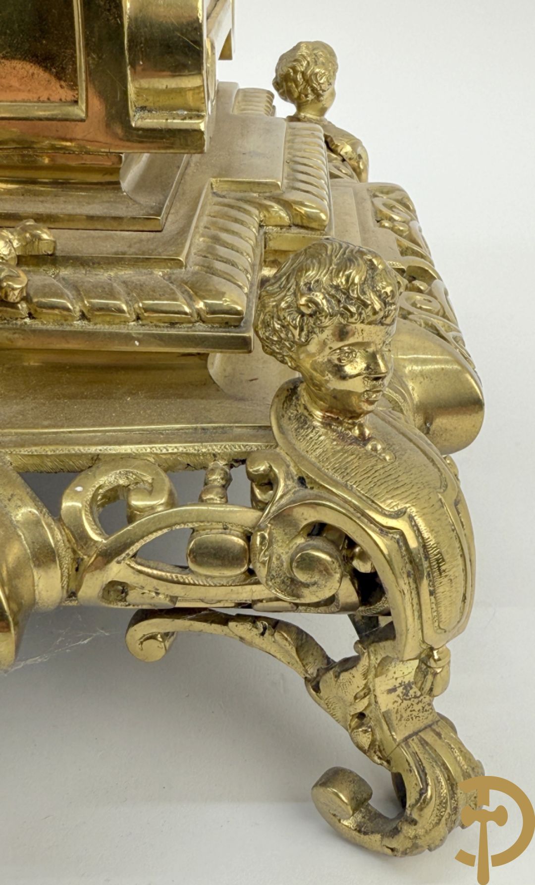 Driedelige bronzen vergulde garntiuur bestaande uit klok met medusahoofden en sfinxen, geflankeerd door paar zevenarmige kandelaars met accanthusranken en sfinxen