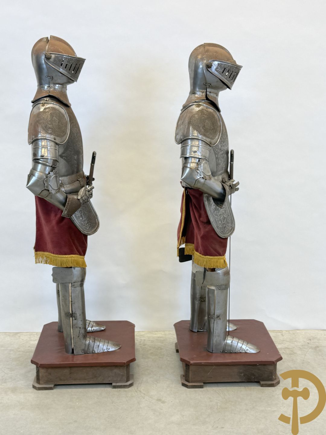 Paar ijzeren decoratieve harnassen ridderuitrusting met geciseleerde motieven op de elementen, met zwaard en ridderhelm - op statief - vermoedelijk Spaans 1930-1940