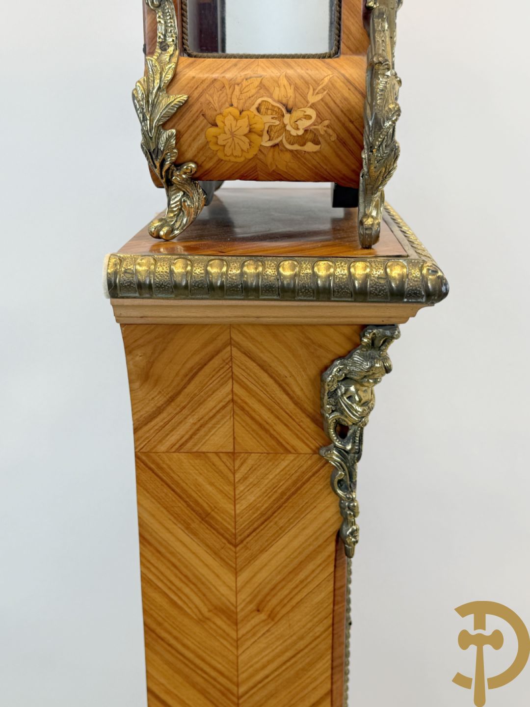 Notelaren pendule met bloemenmarquetterie en bronsbeslag, bovenaan bekroond met bronzen figuur - met bijhorende sokkel in notelaar met bronsbeslag