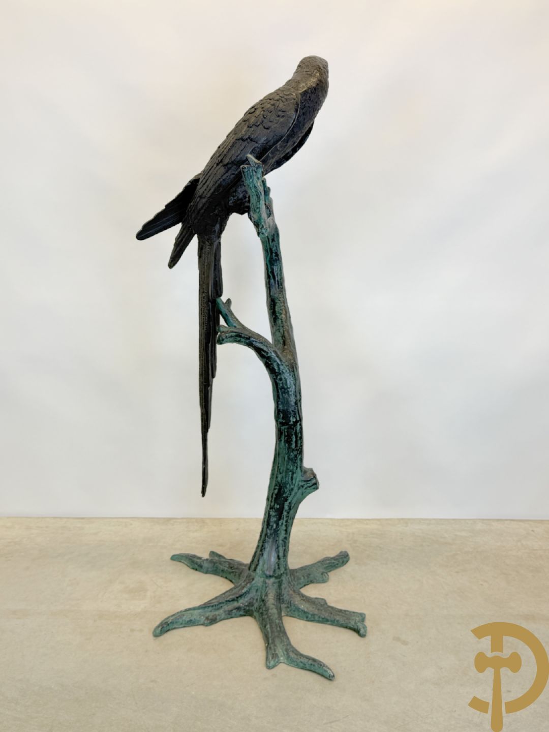 Metalen gepatineerde papegaai op boomstronk