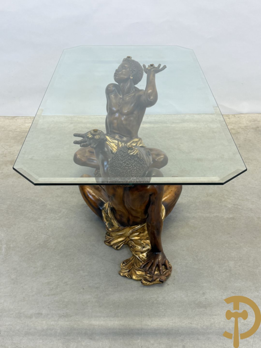 Salontafel met een paar moren met vergulde lendendoek dragende een achthoekig geslepen glazen blad