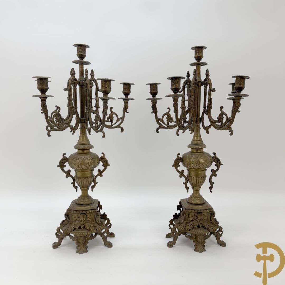Driedelige koperen garnituur, klok geflankeerd door paar vijfarmige kandelaars