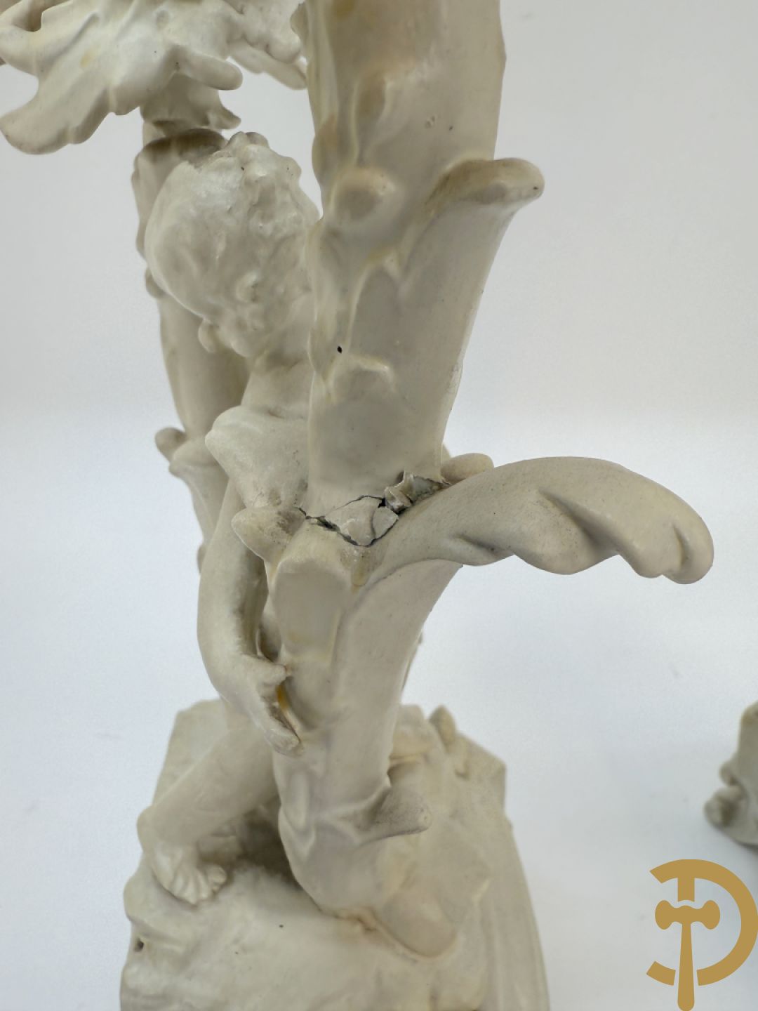 Driedelige porseleinen garnituur bestaande uit pendule bezet met lieftallig koppel, geflankeerd door paar kandelaars met cupido