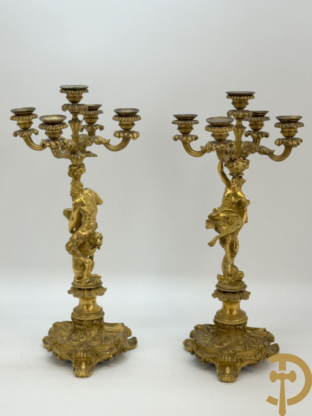 Paar bronzen kandelaars met sater en naakte dame, versierd met accanthusranken en dierenmotieven