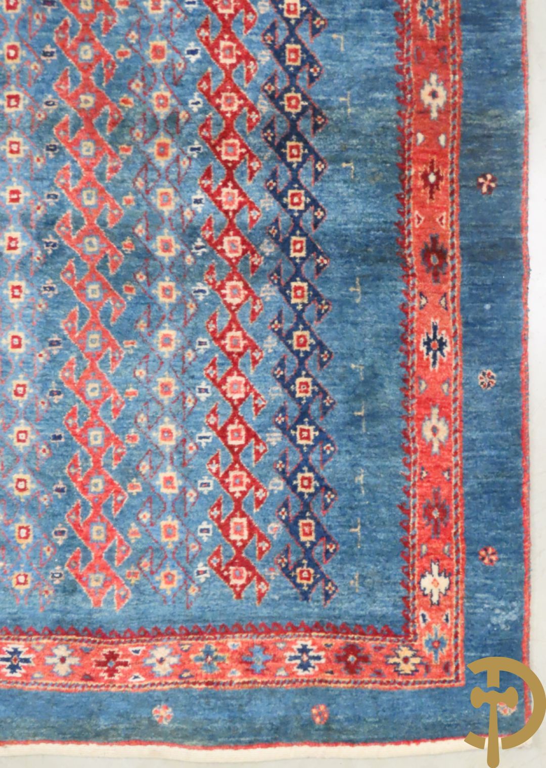 Oosters handgeknoopt tapijt met geometrische patronen op blauwe fond