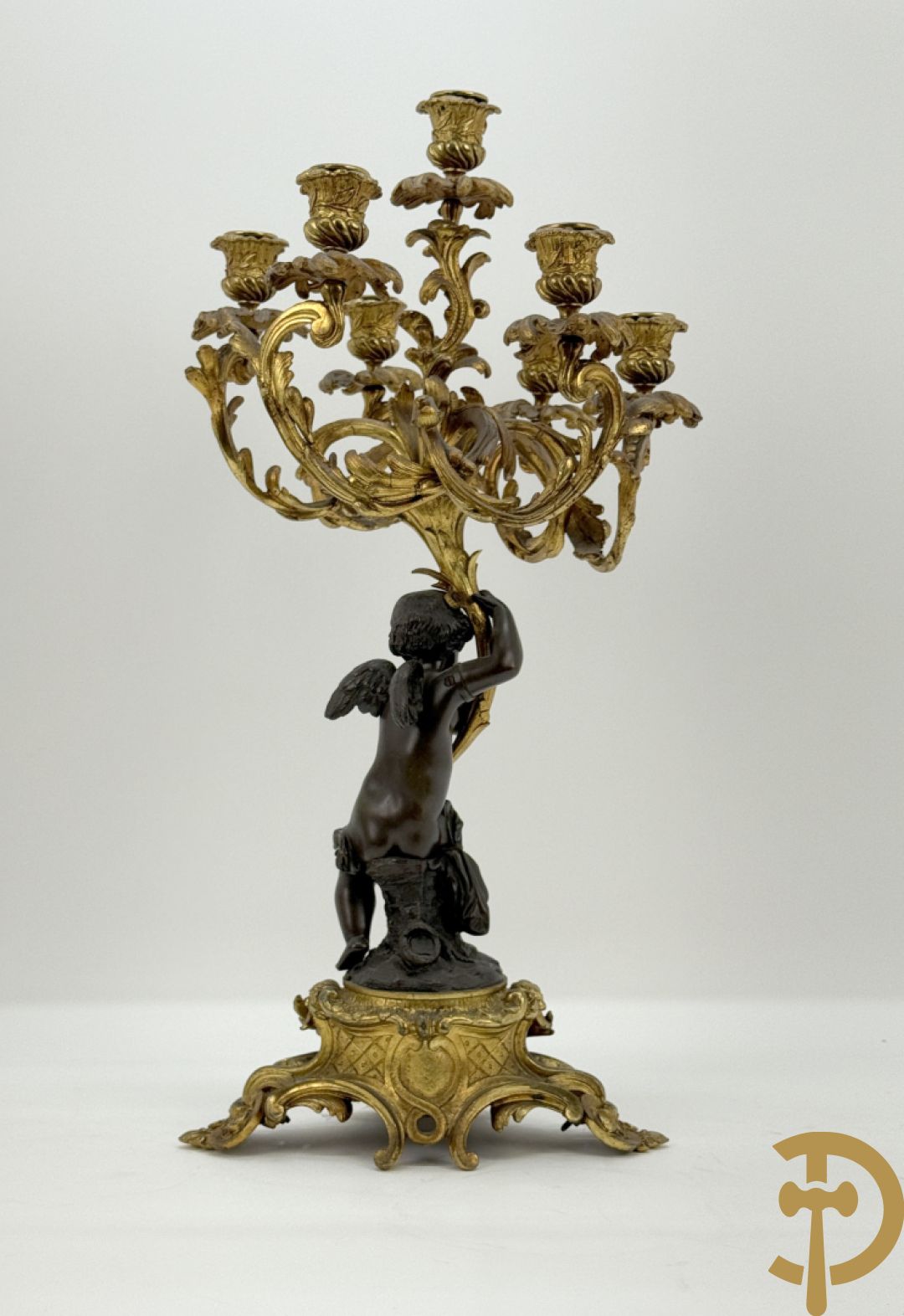 Bronzen cupido dragende een zevenarmige kandelaar