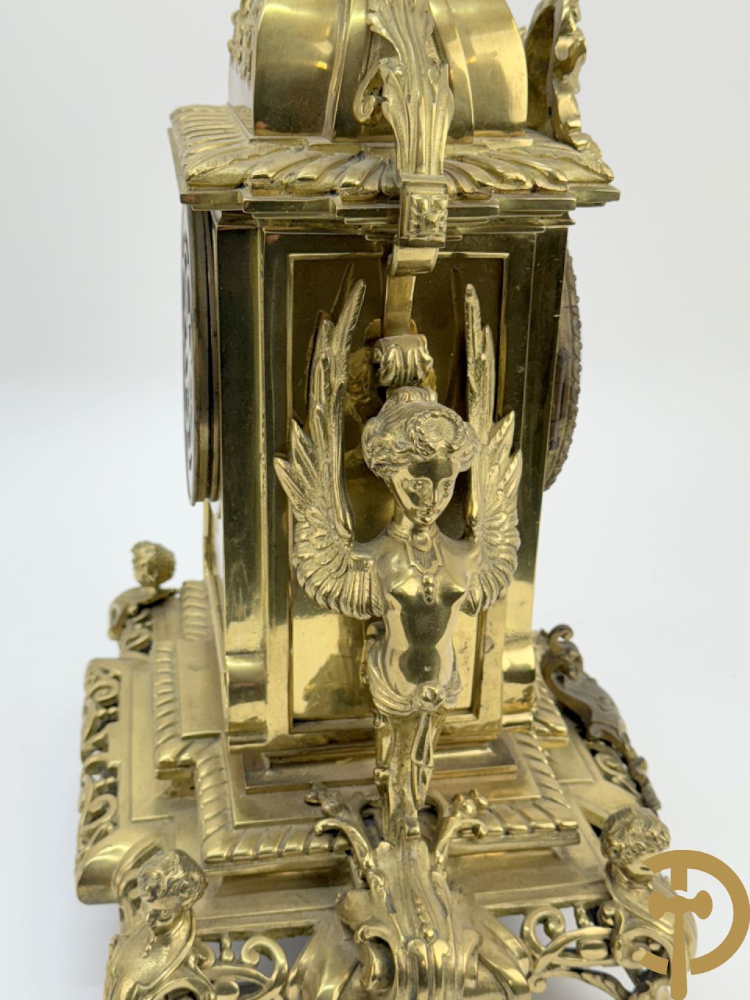 Driedelige bronzen vergulde garntiuur bestaande uit klok met medusahoofden en sfinxen, geflankeerd door paar zevenarmige kandelaars met accanthusranken en sfinxen