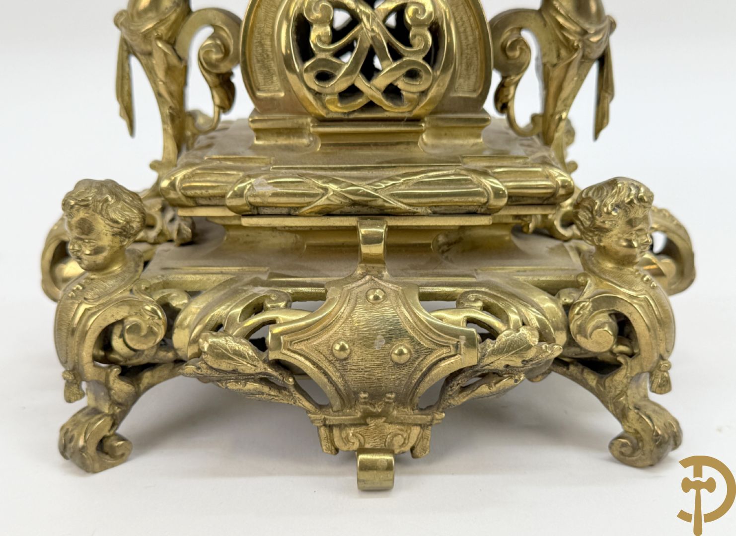 Driedelige bronzen vergulde garntiuur bestaande uit klok met medusahoofden en sfinxen, geflankeerd door paar zevenarmige kandelaars met accanthusranken en sfinxen