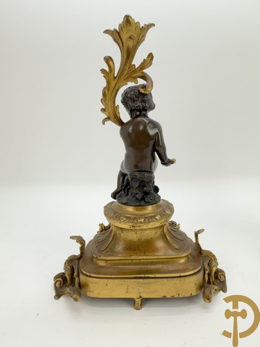 Driedelige bronzen garnituur bestaande uit middenstuk met bronzen vuurvergulde klok, Daubrée gemerkt à Nancy, bovenaan bekroond met Cleopatra met drinkbeker - getekend van Cumberworth sculpteur - geflankeerd door paar cupido