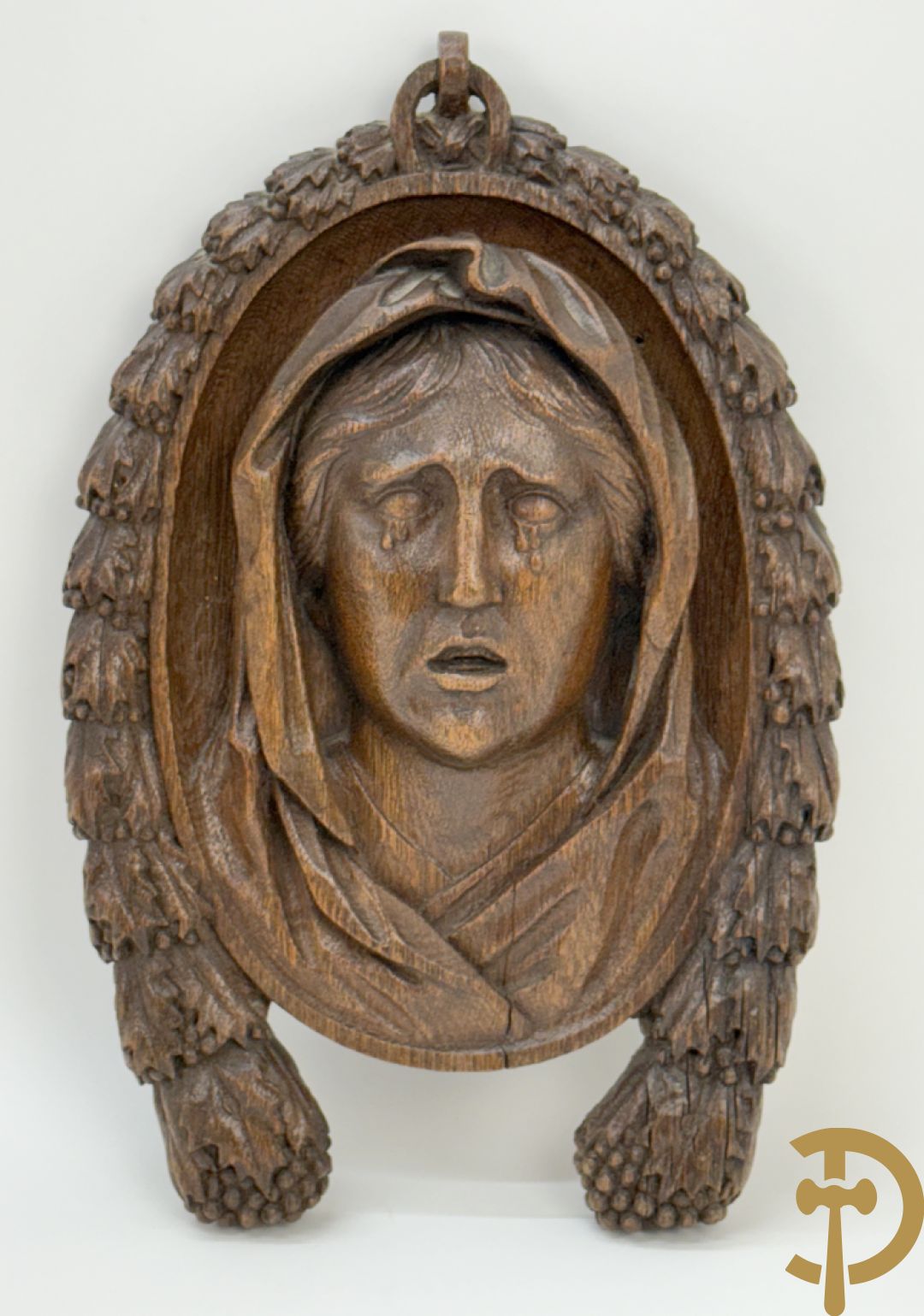 Houtgesculpteerd basrelief van wenende dame in cartouche met accanthusranken
