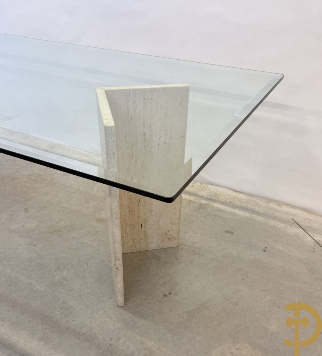 Moderne tafel met geslepen glazen blad op 2 travertin steunen