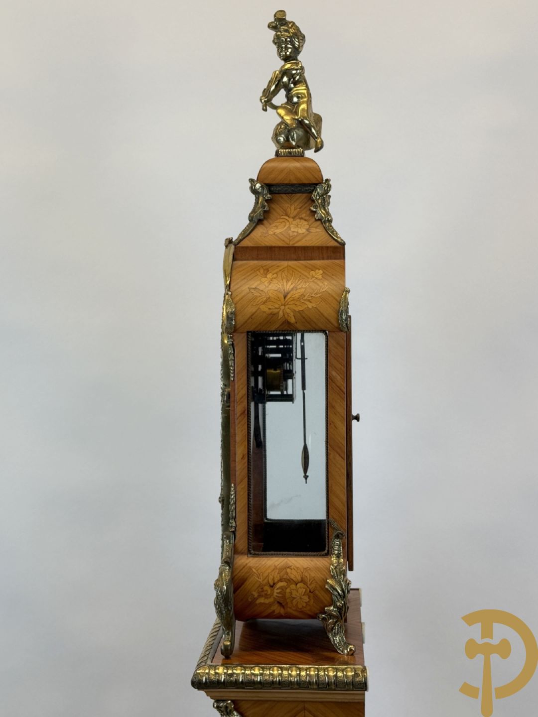 Notelaren pendule met bloemenmarquetterie en bronsbeslag, bovenaan bekroond met bronzen figuur - met bijhorende sokkel in notelaar met bronsbeslag